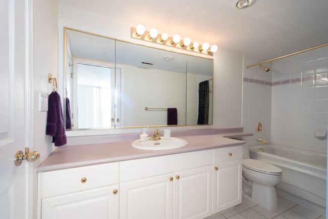 Full bathroom featuring tile patterned floors, shower / bath combination with curtain, toilet, and vanity | Image 31