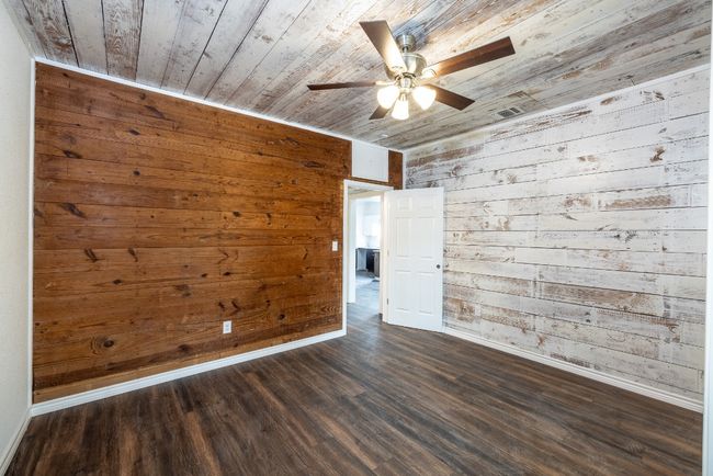 Empty room featuring wooden walls, wood ceiling, baseboards, and a ceiling fan | Image 19