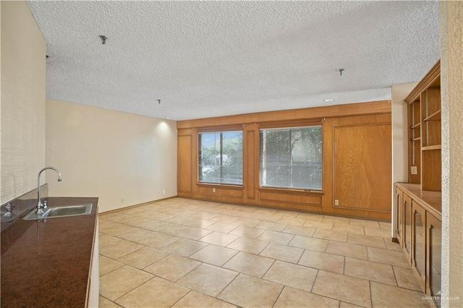 Unfurnished living room featuring a textured ceiling and light tile patterned flooring | Image 10