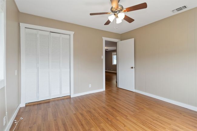 Unfurnished bedroom with a closet, light wood-type flooring, baseboards, visible vents, and ceiling fan | Image 18