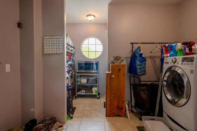 Laundry room with washer / clothes dryer and light tile patterned floors | Image 17