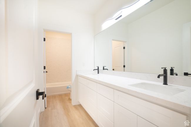 Full bathroom featuring double vanity and wood finished floors | Image 20