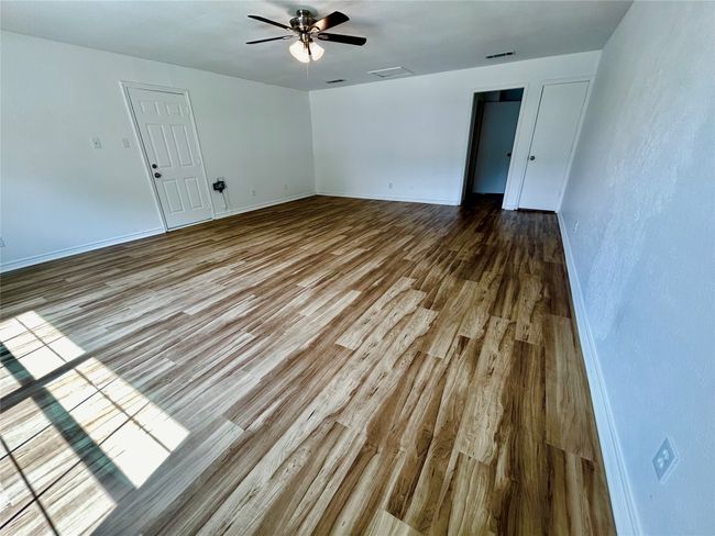 Spare room featuring wood finished floors, ceiling fan, and baseboards | Image 12