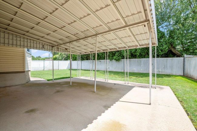 Fenced backyard with a patio area and a carport | Image 23