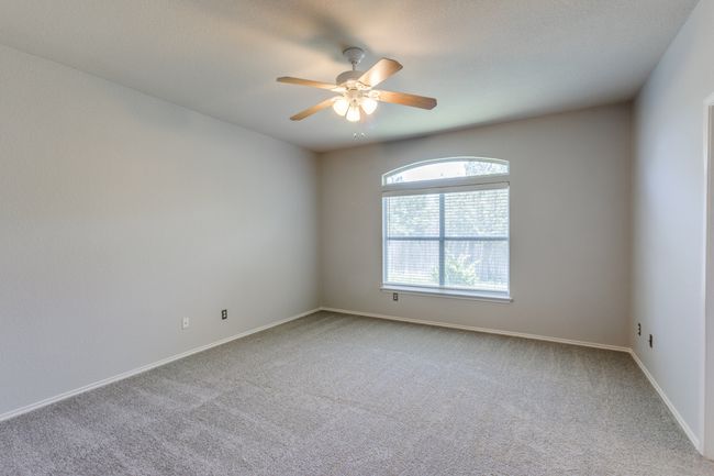 Master Carpeted spare room with ceiling fan and baseboards | Image 26