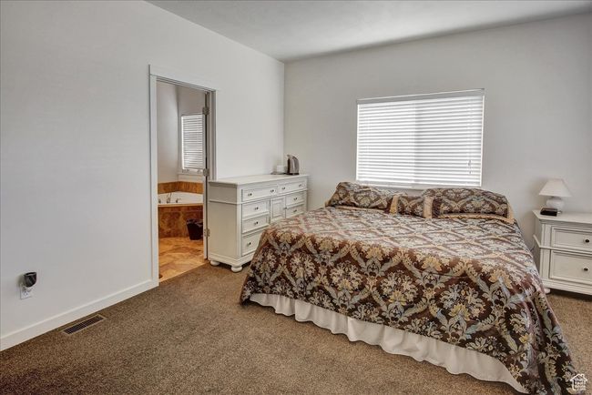 Carpeted bedroom with ensuite bathroom and visible vents | Image 12