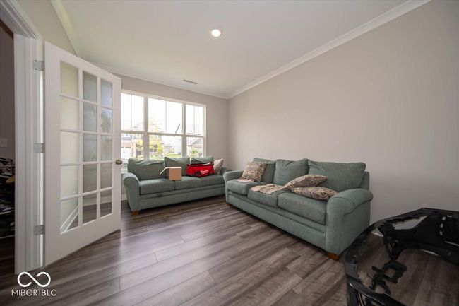 living area featuring wood finished floors, ornamental molding, and recessed lighting | Image 6
