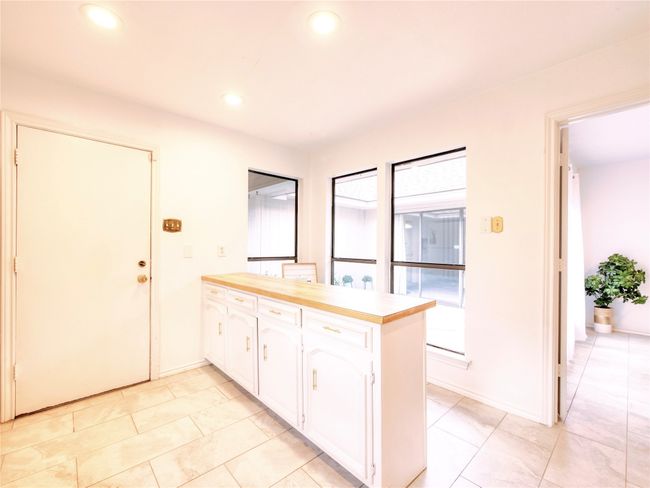 Kitchen featuring white cabinetry, light countertops, recessed lighting, a peninsula | Image 15