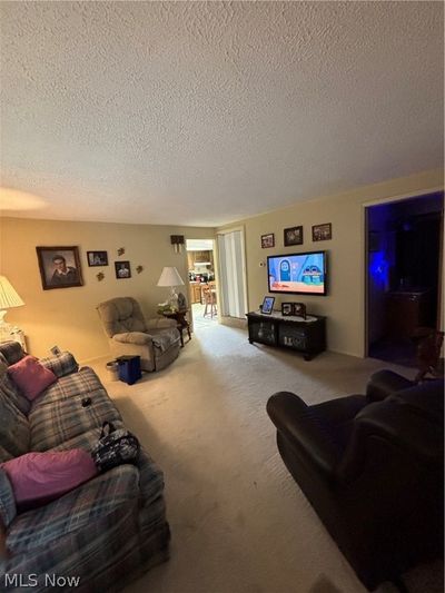 Living room featuring carpet and a textured ceiling | Image 3