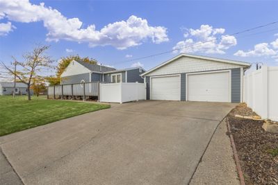 View of front of property featuring an outdoor structure, a front lawn, a wooden deck, and a garage | Image 3