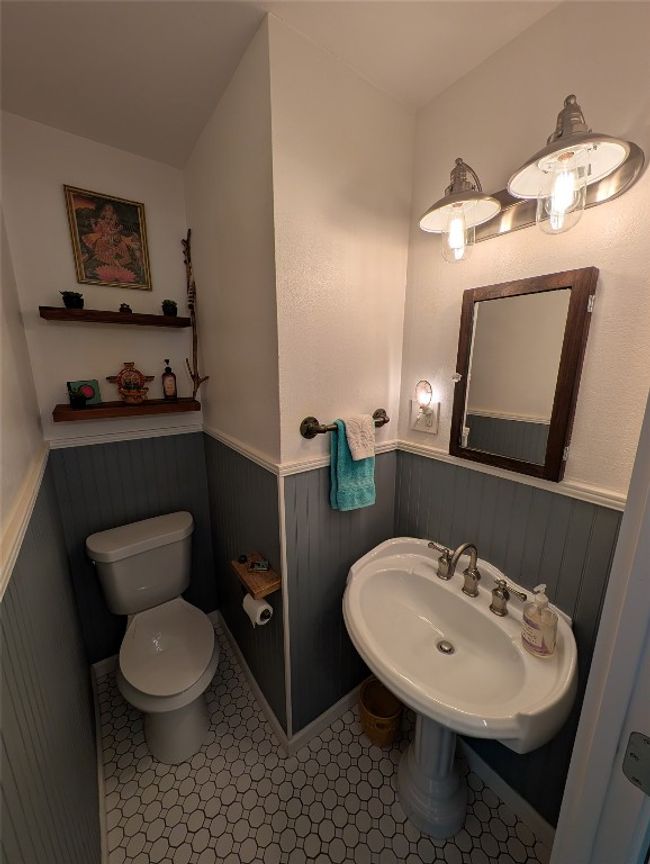 Half Bathroom for your guest. featuring wainscoting, toilet, and sink | Image 14