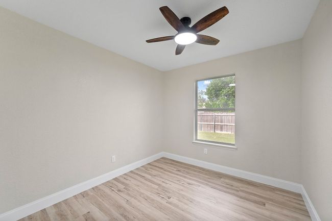 Empty room with light wood finished floors and a ceiling fan | Image 23