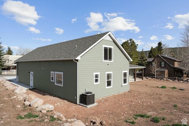 Rear view of property with roof with shingles, central AC unit, and fence | Image 45