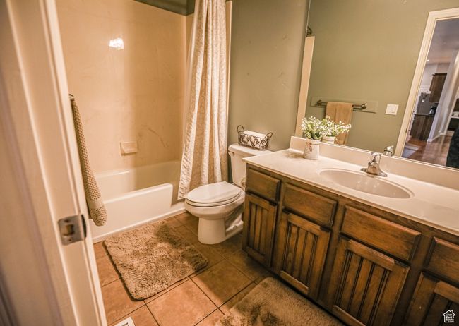 Full bathroom with toilet, tile patterned floors, shower / bath combo, and vanity | Image 34