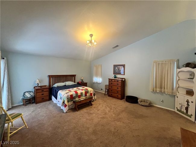 Bedroom with vaulted ceiling, carpet floors, and a chandelier | Image 27