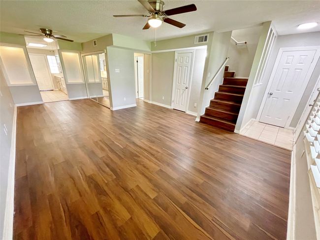 Unfurnished living room with wood finished floors, stairs, and ceiling fan | Image 20