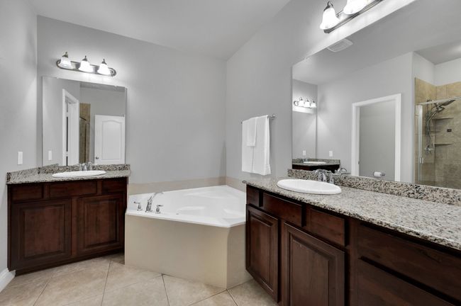 Master bathroom with view of both vanities and sinks; deep soaker tub plus over-sized walk in shower. | Image 17