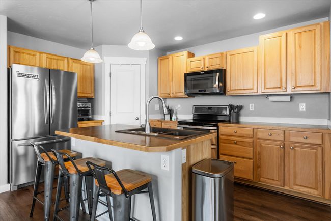 Kitchen with newer appliances, pantry, recessed lighting, a breakfast bar, and a center island with sink | Image 12
