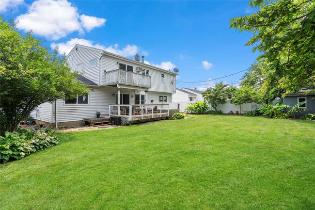 Rear view of house featuring a balcony, a fenced backyard, a wooden deck, and a chimney | Image 34