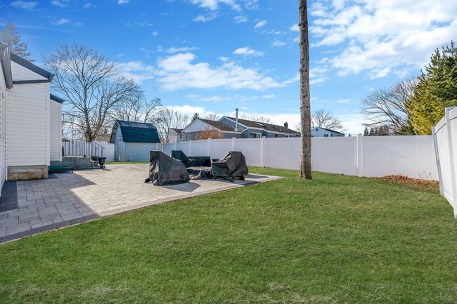 View of yard featuring a storage shed and a patio area | Image 22