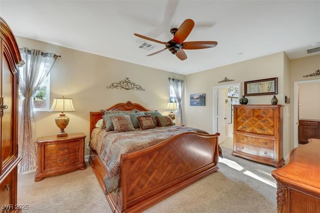 Bedroom with visible vents, multiple windows, a ceiling fan, and light colored carpet | Image 23