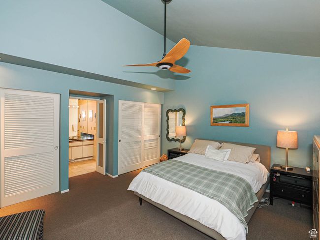 Carpeted bedroom featuring high vaulted ceiling, connected bathroom, a closet, and a ceiling fan | Image 29