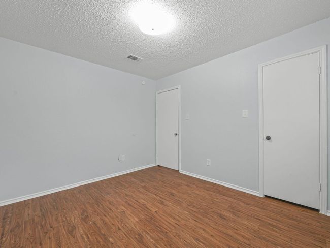 Empty room with wood finished floors and a textured ceiling | Image 14