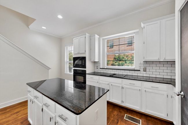 Kitchen with crown molding, tasteful backsplash, dark wood finished floors, white cabinetry, and recessed lighting | Image 18