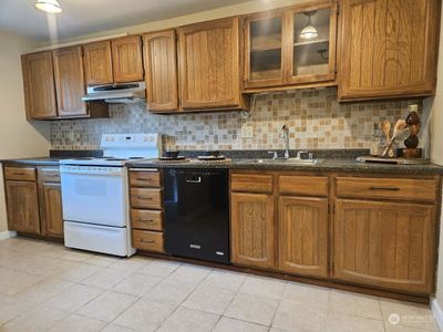 An efficient kitchen with plenty of cabinets for storage | Image 2