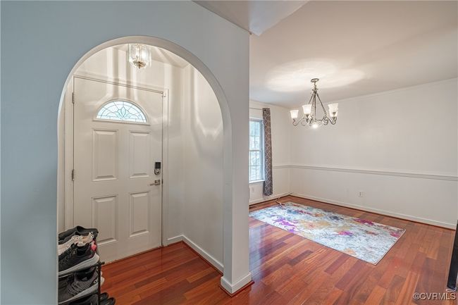 Entryway with a chandelier, healthy amount of natural light, wood finished floors, and arched walkways | Image 4