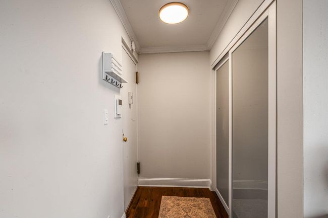 Hallway featuring crown molding and dark wood finished floors | Image 8