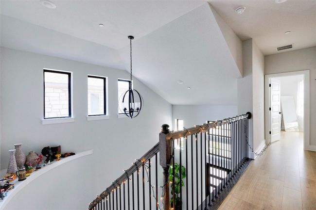 Corridor with an upstairs landing, visible vents, a chandelier, baseboards, and light wood-style floors | Image 14