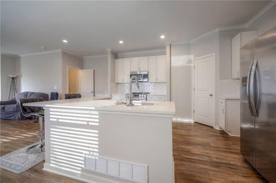 Kitchen an island with sink, and appliances with stainless steel finishes | Image 2