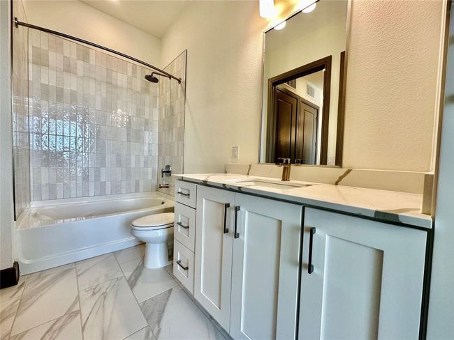 Full bathroom with tiled shower / bath combo, toilet, and vanity | Image 8