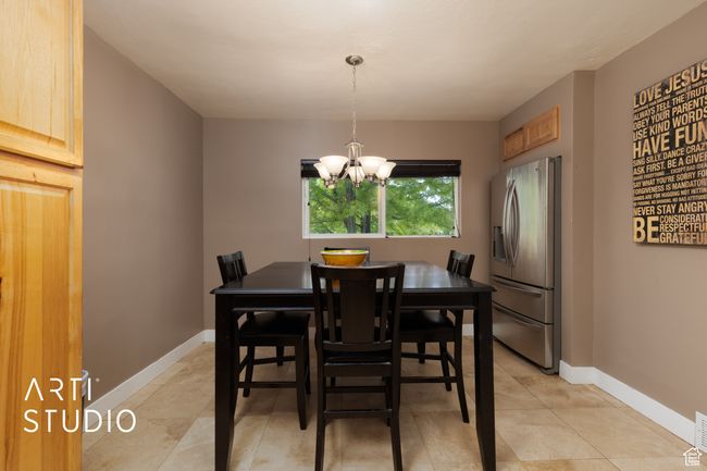Dining area with a chandelier, light tile patterned floors, and baseboards | Image 41