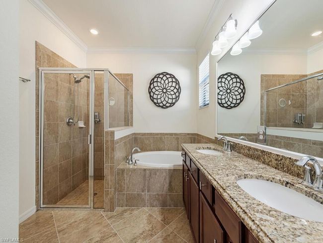 Bathroom with a stall shower, a sink, a bath, and crown molding | Image 6