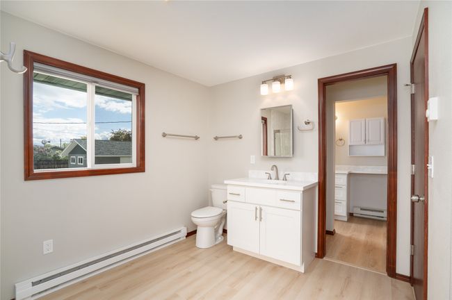 Bathroom featuring a baseboard radiator, wood finished floors, vanity, and toilet | Image 17