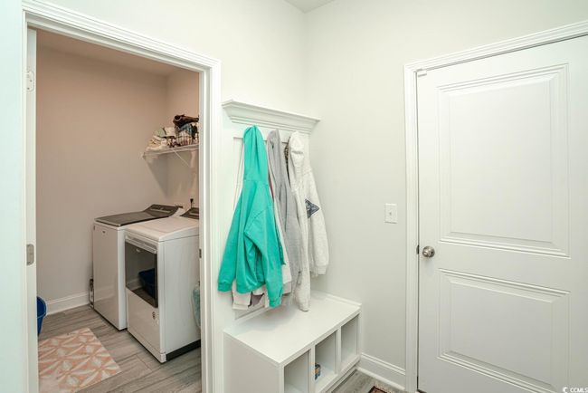 Washroom with washing machine and dryer, light wood finished floors, and baseboards | Image 36