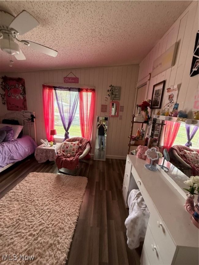 Bedroom with a ceiling fan, a textured ceiling, and dark wood-type flooring | Image 20