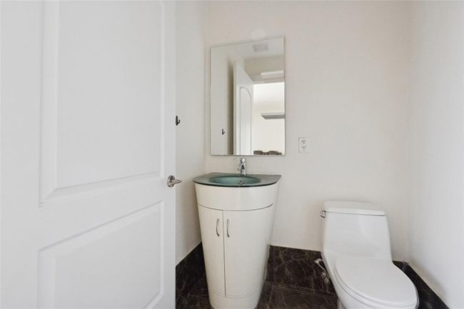 Bathroom with toilet, marble finish floor, and vanity | Image 11