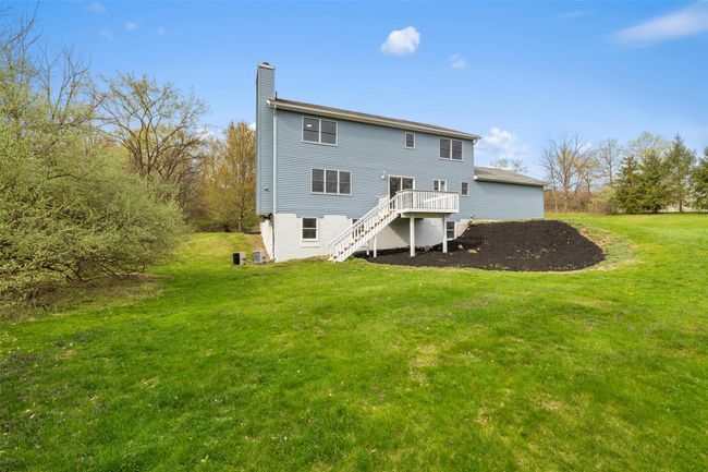 Rear view of house with stairs, a yard, a wooden deck, and a chimney | Image 32