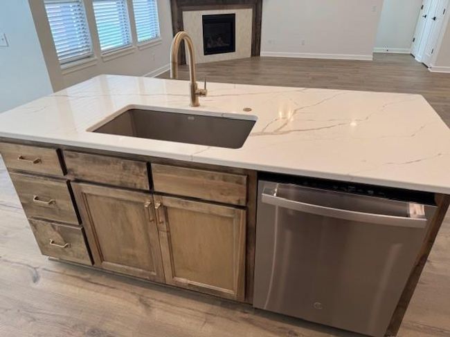 Kitchen featuring a sink, dishwasher, light stone counters, and wood finished floors | Image 16