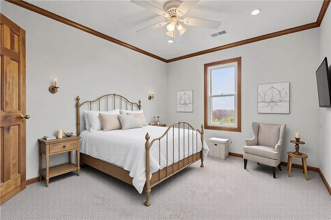Bedroom featuring baseboards, visible vents, a ceiling fan, light colored carpet, and ornamental molding | Image 35