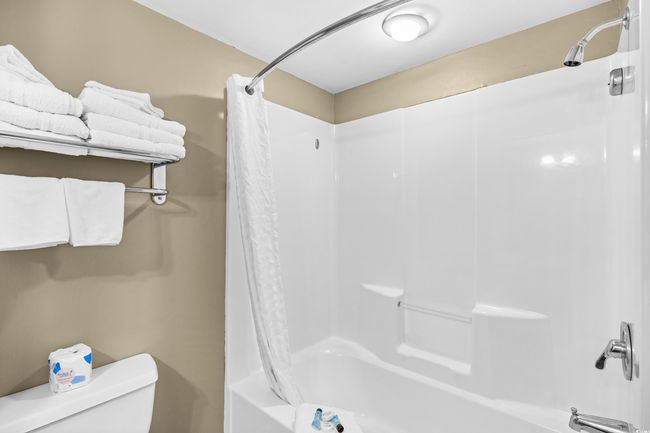 Bathroom featuring toilet and shower / bathtub combination with curtain | Image 13