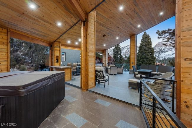 View of patio / terrace with outdoor dining area, a hot tub, a mountain view, and outdoor lounge area | Image 76
