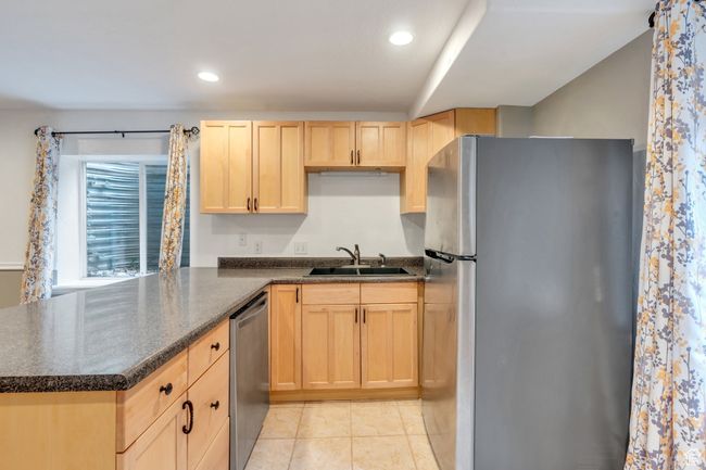 Kitchen with light brown cabinets, a sink, stainless steel appliances, a peninsula, and recessed lighting | Image 21