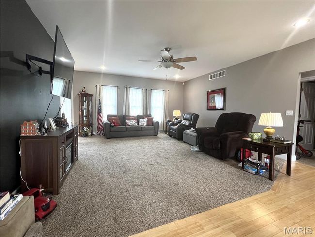 Living room with ceiling fan and light wood-style flooring | Image 18
