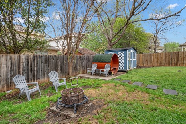 View of yard featuring a fenced backyard, a fire pit, a shed, and an outbuilding | Image 21