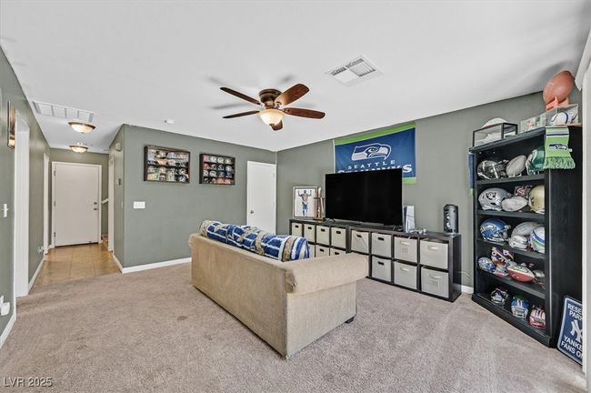 Carpeted living room with baseboards, a ceiling fan, and attic access | Image 18