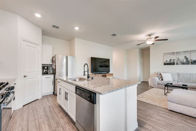 Kitchen featuring stainless steel appliances, open floor plan, light stone countertops, light wood-style floors, and recessed lighting | Image 8